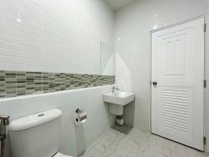un bagno bianco con un water e un lavandino di DelZiaNa Bara Budget พักได้ 2 ท่าน a Satun Altre 34 foto