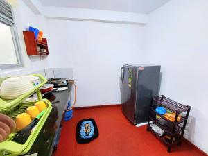 a kitchen with a refrigerator and a red floor at Samuu Homestay Mirissa in Mirissa