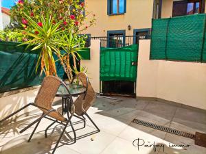 un patio con 2 sedie e un tavolo in vetro di Maison de bourg avec terrasse a Gerzat