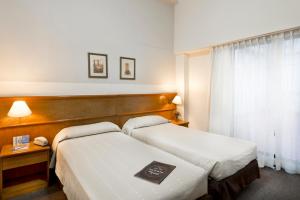 A bed or beds in a room at Crisol Suites Catalinas