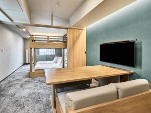 a room with a bed and a desk with a tv at MIMARU Tokyo Ikebukuro in Tokyo