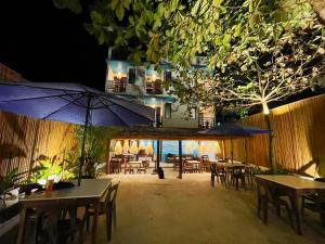 a restaurant with tables and umbrellas at night at Amos Portside Inn El Nido in El Nido