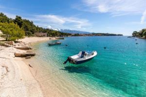 a boat in the water on a beach at Apartment Karmen in Sumartin