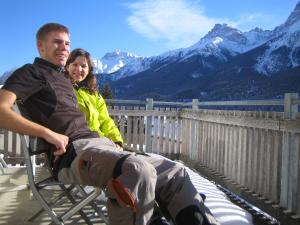 a man and a woman sitting on a chair with mountains at Senda 517 C in Scuol