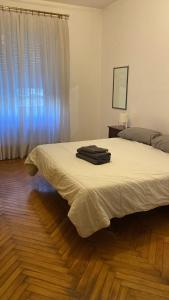 a bedroom with a bed with white sheets and a window at La Milonga 2 - AFFITO CAMERE - Habitacion - Baño y Cocina Compartida in Genova