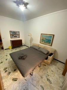 a bedroom with a large bed and a couch at La Milonga 2 - AFFITO CAMERE - Habitacion - Baño y Cocina Compartida in Genova +6 photos