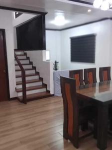 a dining room with a table and a staircase at casa lilia in Tagaytay +2 photos