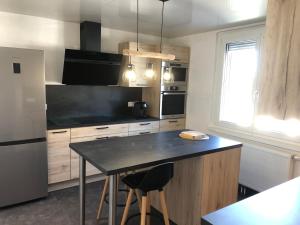 a kitchen with a table and a black counter top at Au cœur de Maîche in Maîche