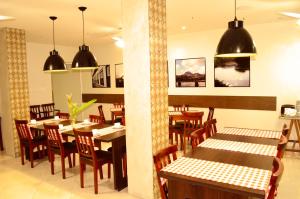 a dining room with wooden tables and chairs at Hotel São José in São Fidélis