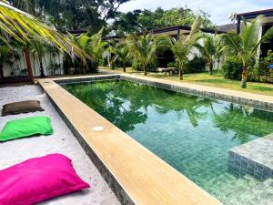 a swimming pool with a wooden bench next to a house at AQUA Boutique Resort & Pool in Ko Phayam +16 photos