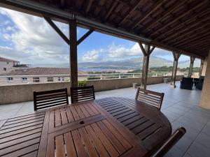 ein Holztisch und zwei Stühle auf einer Terrasse in der Unterkunft Appartement avec vue imprenable sur la mer, terrasse et piscine in Propriano