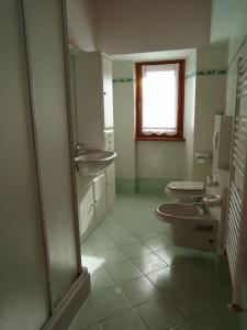 a bathroom with two sinks and two toilets at Casa del Sole in Casasco Intelvi +16 photos