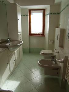 a bathroom with two toilets and a sink at Casa del Sole in Casasco Intelvi