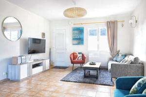 a living room with a couch and a tv at Le Poulpe Bleu - Maison 6p avec jardin in Saint-Jean-de-la-Rivière
