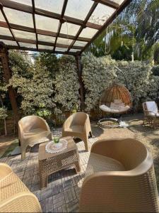 acovered patio with chairs and a table and a swing at كمبوند مفيدا in New cairo