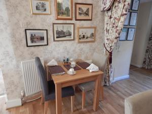 una sala da pranzo con tavolo e sedie in legno di Fairlight Lodge a Kings Lynn
