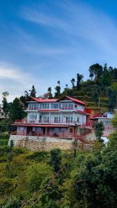a house on top of a hill with trees at Panorama Villa at Hartola by Kusumith Retreats in Rāmgarh +78 photos