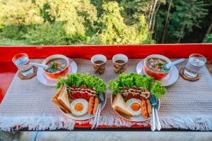 Ban Huai HanHappy camp phuchifa แฮปปี้แคมป์ ภูชี้ฟ้า的一张桌子,上面放着两盘食物和两三明治