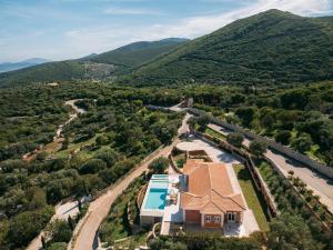 an aerial view of a house with a swimming pool and mountains at Archontiko Stoufi, an Authentic SeaView Retreat, By ThinkVilla in Skinária