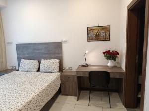 a bedroom with a bed and a desk with a chair at Skynest Residences by Lisa's Paradise C in Nairobi +53 photos