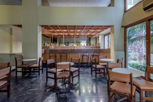 a dining room with tables and chairs and a bar at El Greco Hotel in Heraklio