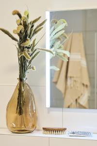 a vase with flowers in it sitting on a counter at Apartment C12 "Pine Hill Resort" in Zirchow