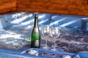a bottle of wine and two wine glasses on a table at Rodzinny zakątek "U Głuszków" Bieszczady in Myczkowce