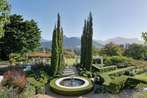 a garden with a fountain and trees at Farm Lorraine The Loft Cottage in Franschhoek