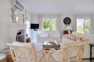 a living room with white furniture and a fireplace at Farm Lorraine The Loft Cottage in Franschhoek