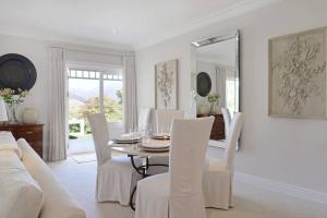 a dining room with a table and chairs and a mirror at Farm Lorraine The Loft Cottage in Franschhoek