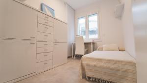 a white bedroom with a bed and a dresser at SeaHomes Vacations - Villa Serenity Cala Canyelles in Lloret de Mar