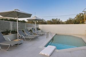a swimming pool with lounge chairs and an umbrella at Villa Bella Gonia in Gonia +62 photos