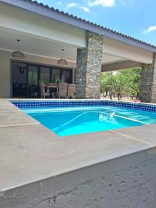 a swimming pool in front of a house at Taíta Lodge in Marloth Park