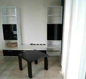 - une table basse noire dans une chambre avec des étagères dans l'établissement Guest House Residence Malpensa, à Case Nuove