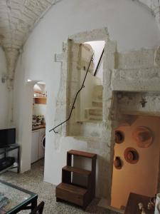 a living room with a stone fireplace with a wooden stool at Casa Vacanze Cattedrale in Ostuni