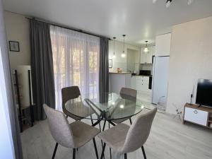 a dining room with a glass table and chairs at Cozy Apartment in Sighnaghi