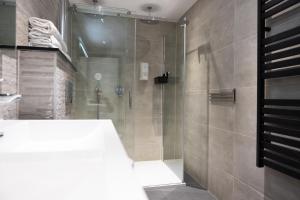 a bathroom with a shower with a glass door at La Casita bed and breakfast in Voorschoten +22 photos
