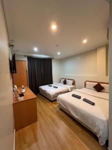 a hotel room with two beds and a television at Kangsar Hotel in Kuala Kangsar