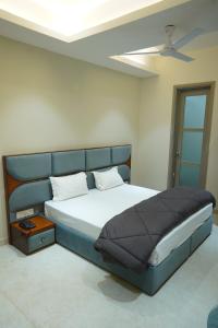 a bedroom with a large bed with a ceiling fan at OVEL Hotel & RESORT in Ludhiana