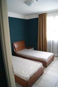 1 dormitorio con 2 camas y ventana en Guest House Residence Malpensa, en Case Nuove