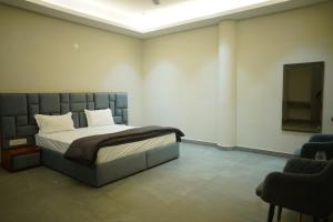 a bedroom with a bed and two chairs and a tv at OVEL Hotel & RESORT in Ludhiana