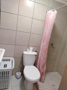 a bathroom with a toilet and a shower curtain at Rustig by die See in Bettyʼs Bay