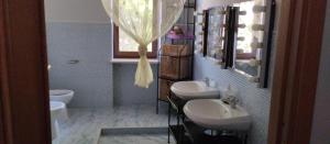 un bagno con due lavandini e un water di Albachiara B&B a Lucera