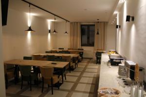 a dining room with tables and chairs and lights at VINOTEL BRZICA Aljmaš in Aljmaš