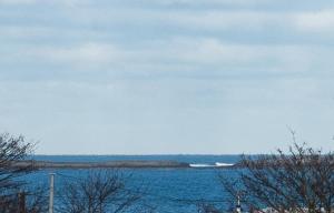 a large body of water with a boat in the distance at Harbour Heights by Coast & Country Stays in Seahouses