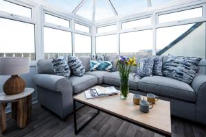 a living room with a couch and a table at Harbour Heights by Coast & Country Stays in Seahouses +22 photos