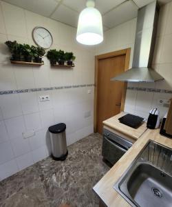 a kitchen with a sink and a clock on the wall at Apartamento con jacuzzi in Cartagena