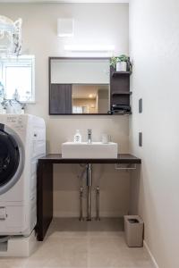 a bathroom with a sink and a washing machine at Snow House LANKA in Furano +83 photos