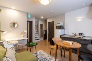 a living room with a couch and a table and a kitchen at Snow House LANKA in Furano