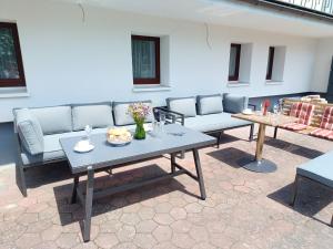 a patio with couches and tables with flowers on it at Ferienhaus Birkelbach in Erndtebrück